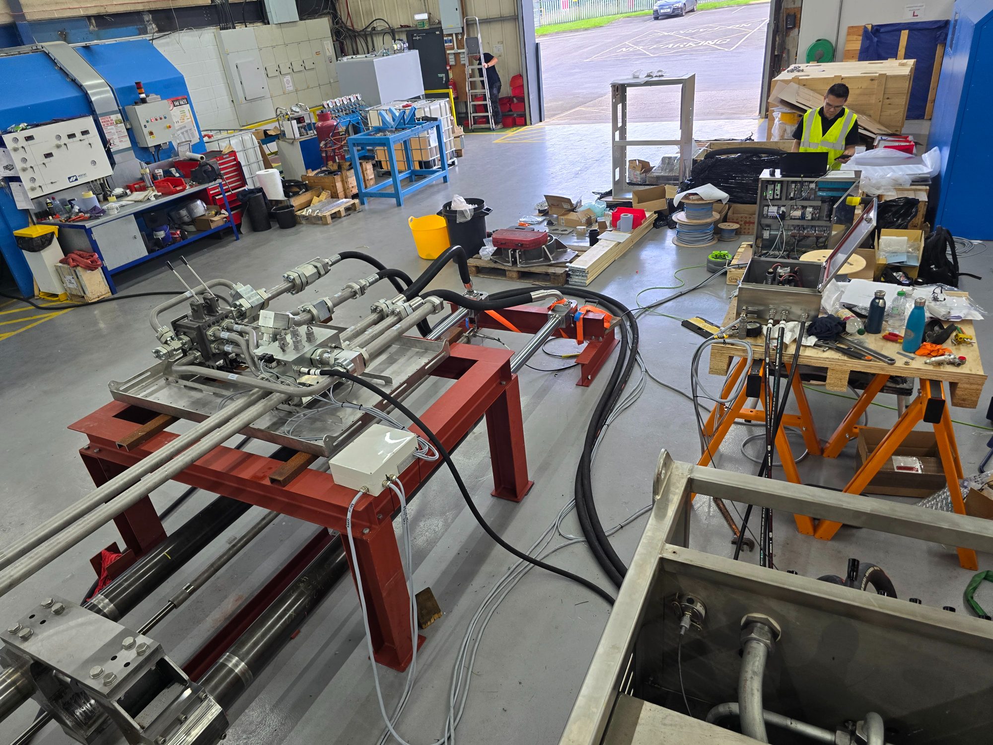Hydraulic system being assembled and tested on a workshop floor