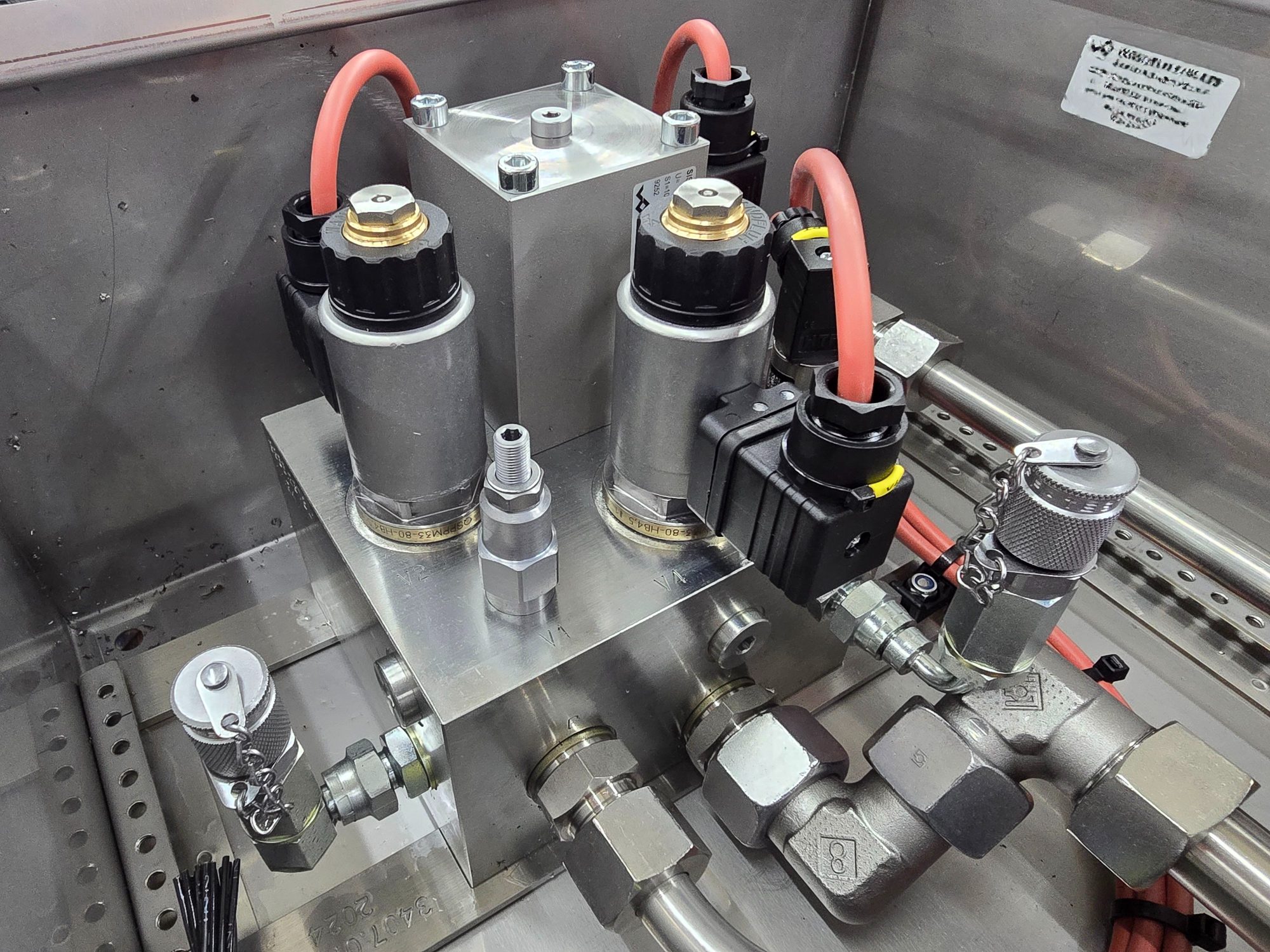 Hydraulic manifold block fitted with solenoid valves and hose connections