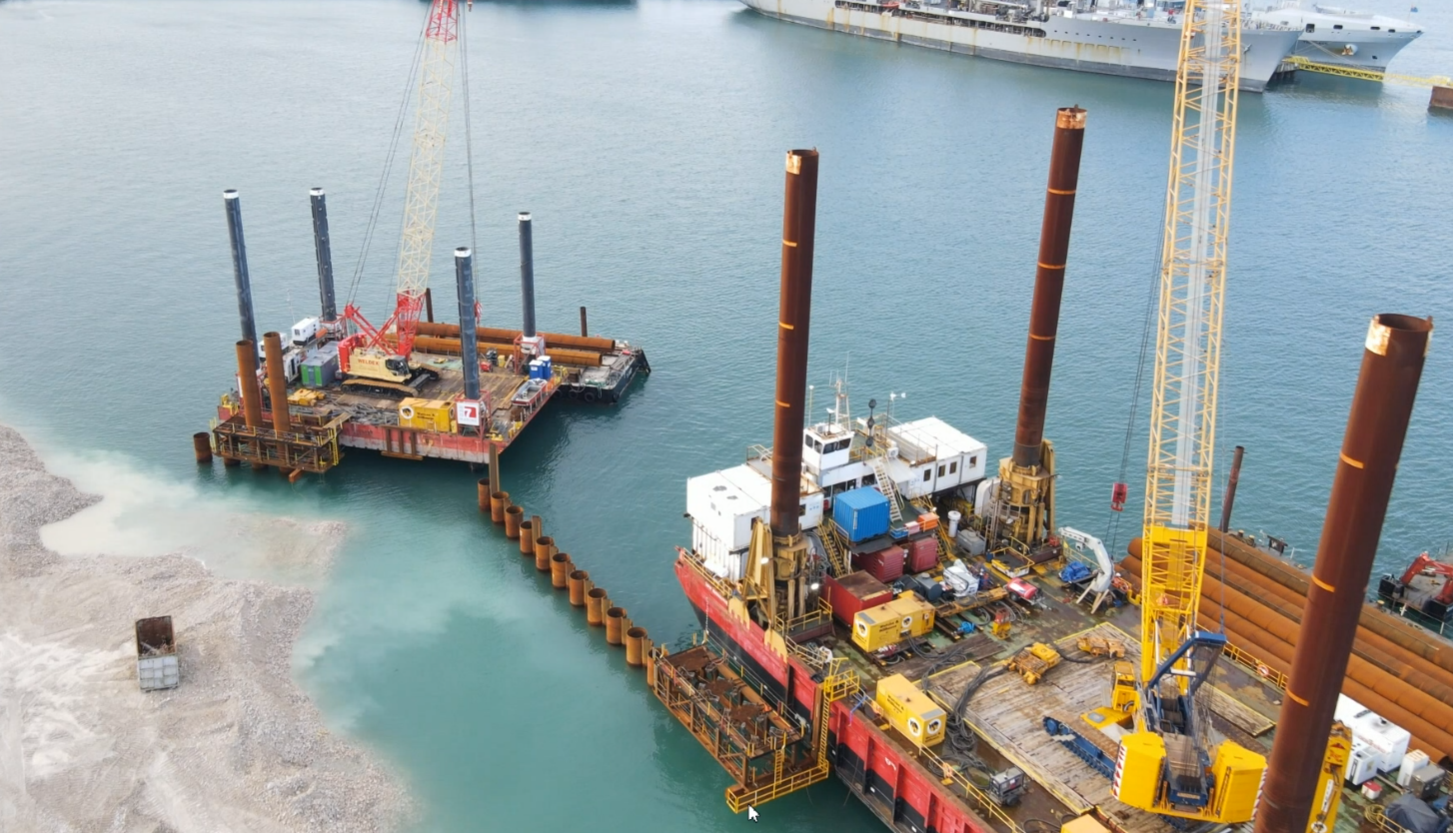Aerial view of jack-up barges installing a row of tubular piles for a new berth