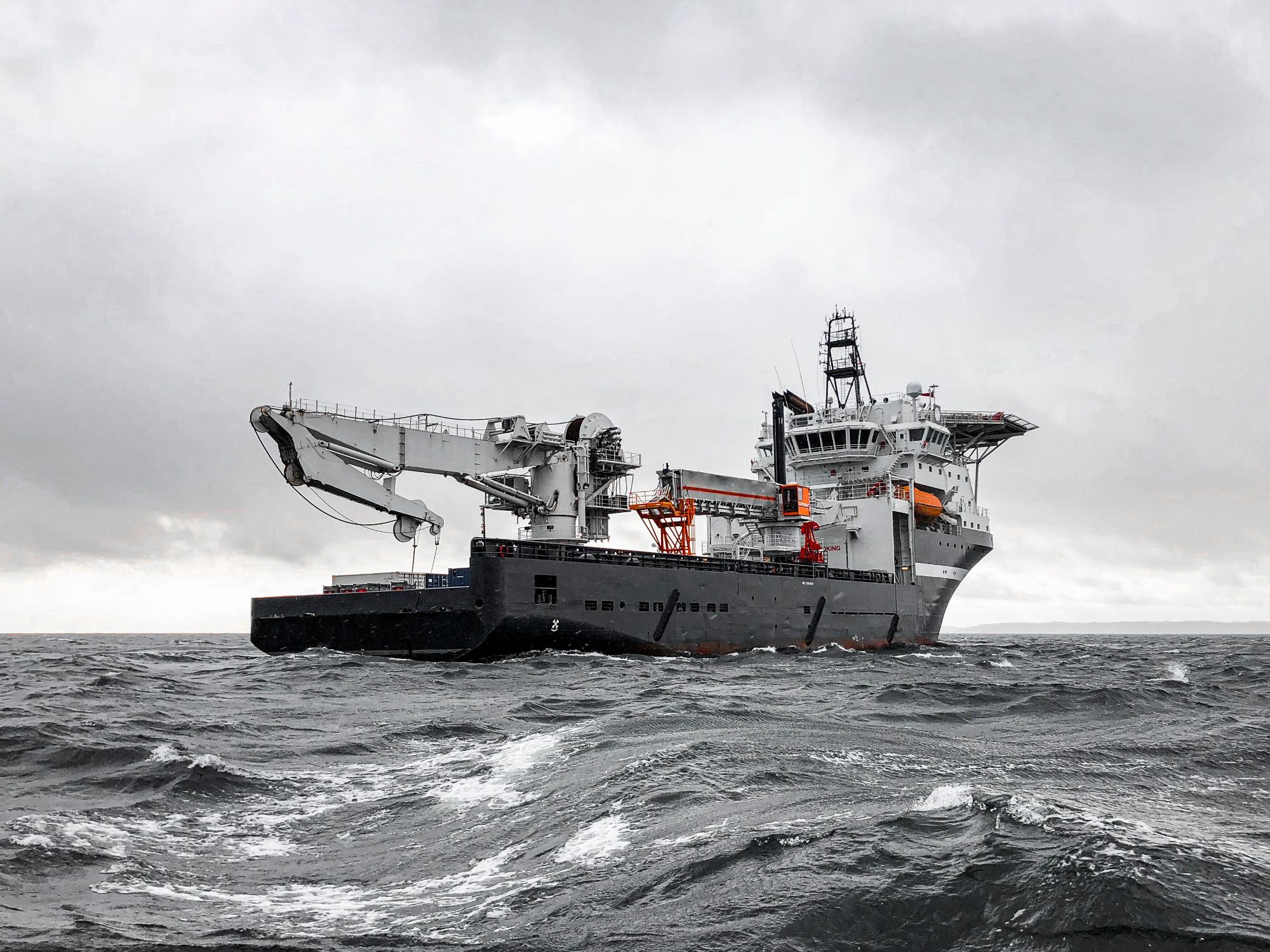 Offshore support vessel with a deck crane working in a heavy grey sea