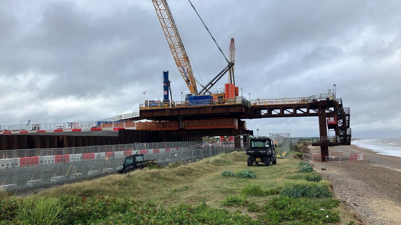 Steel access trestle and crane extending from the shore across a shingle beach
