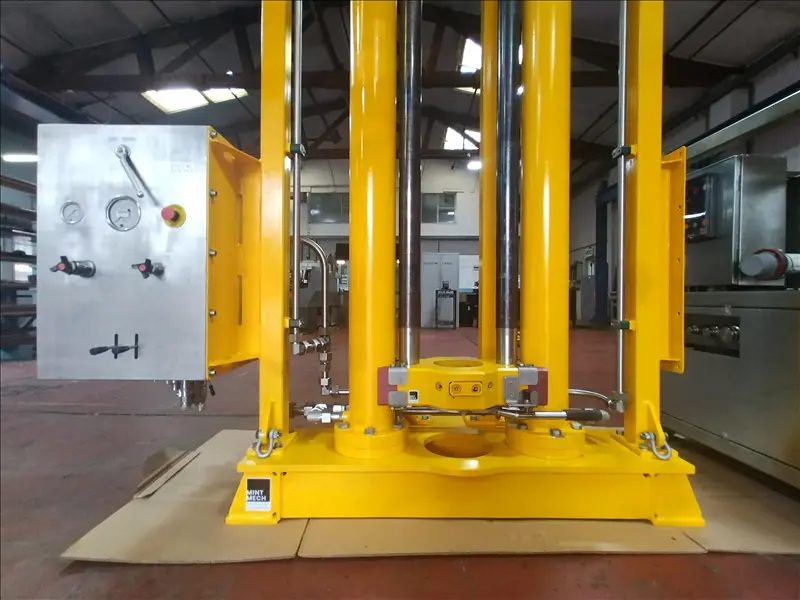 Yellow sampling frame with guide columns beside a stainless steel control cabinet