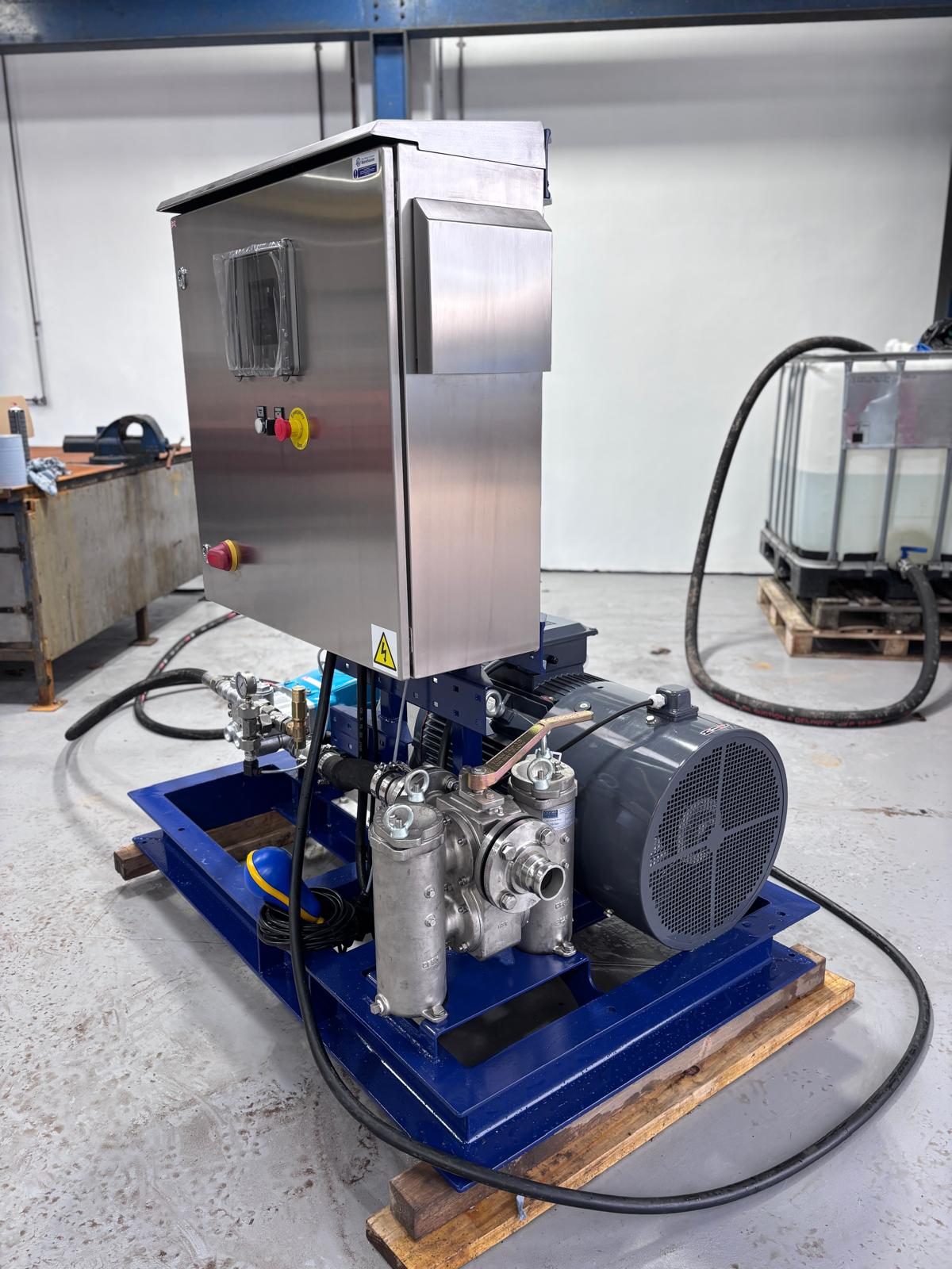 Pumping skid with an electric motor and a stainless steel control cabinet on a blue base frame