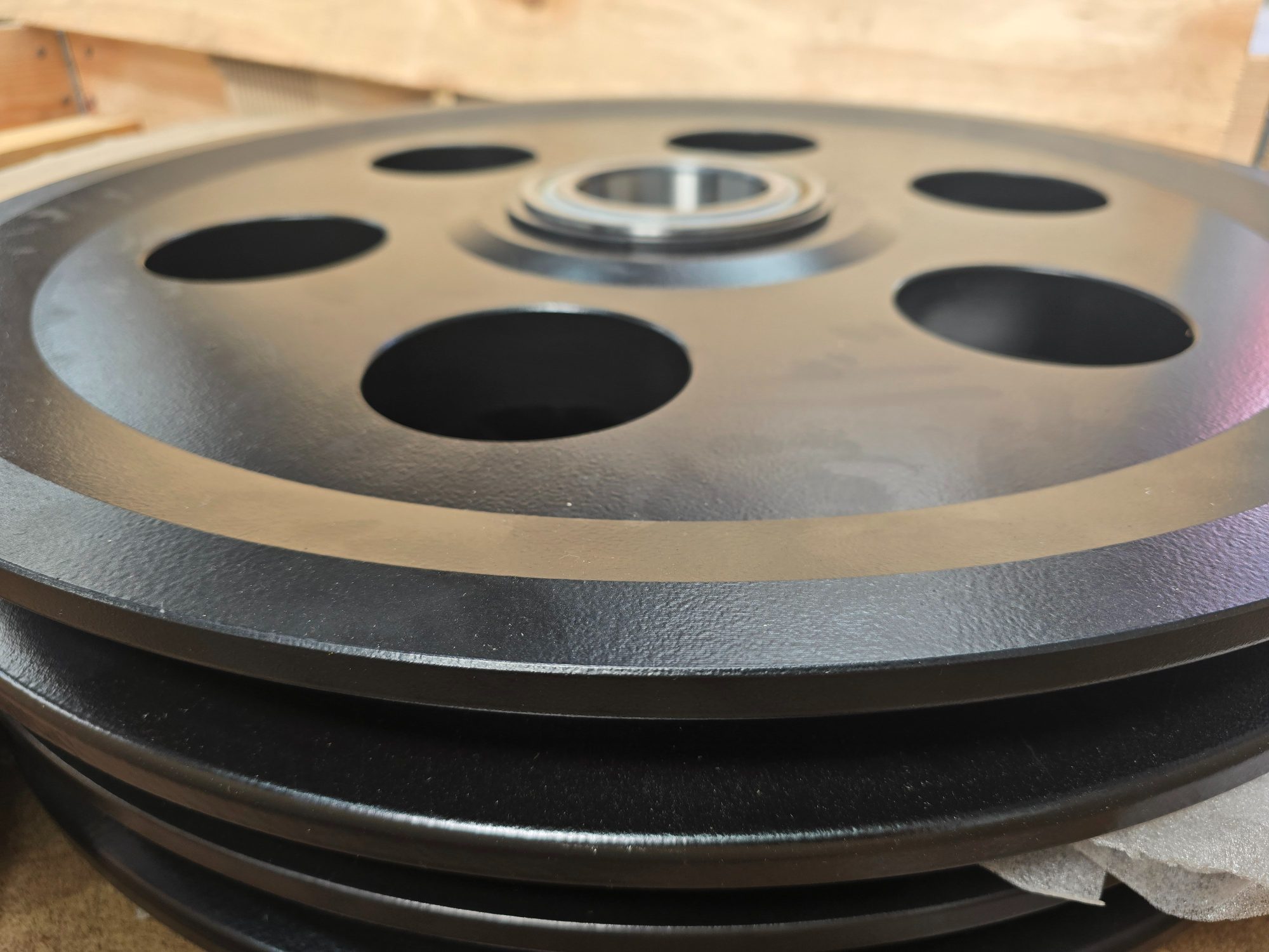 Stack of large black steel sheaves with machined bores