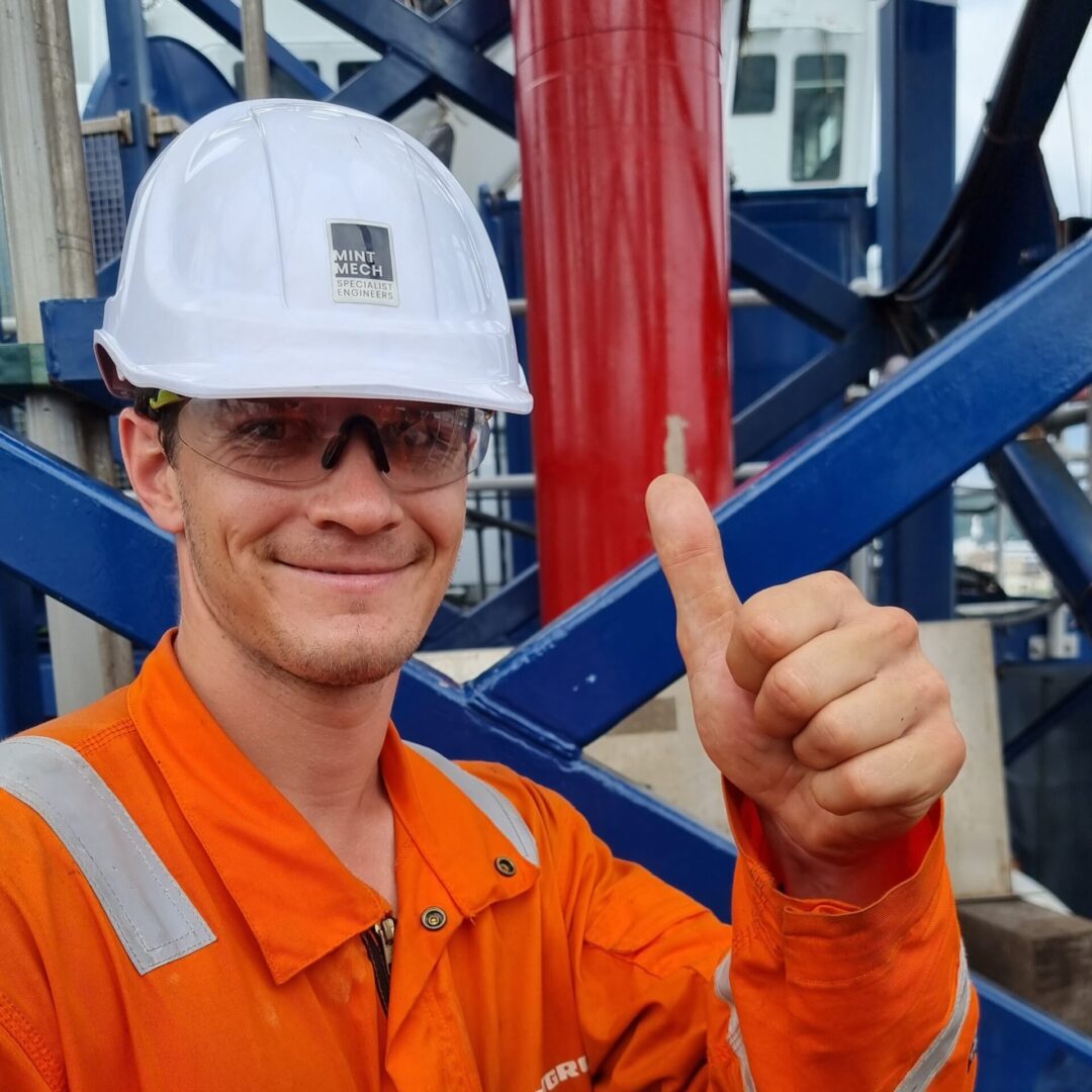 A happy engineer smiling and giving a thumbs up signal